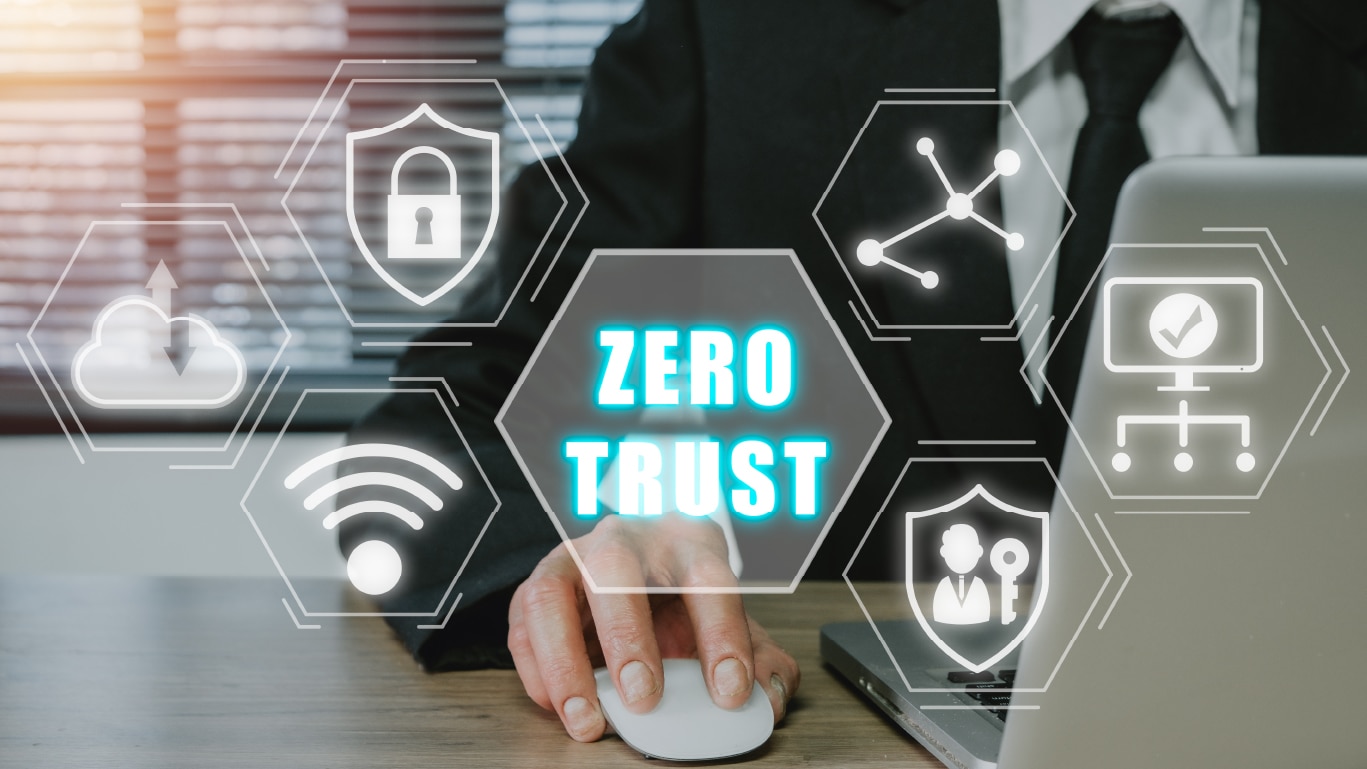 Professional using a computer mouse with digital security icons and the words "zero trust" displayed prominently.